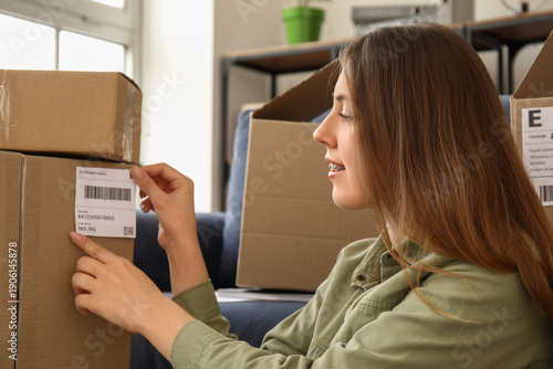 Young woman packing parcel ...