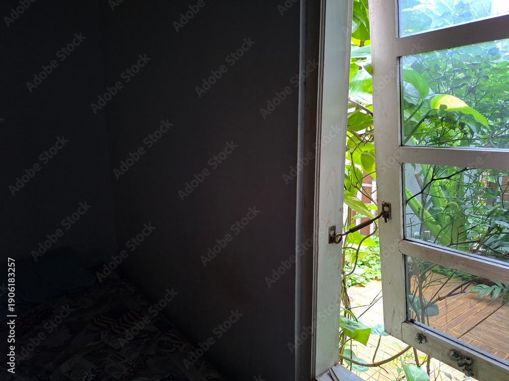 Fototapeta premium Open Window with Green Plants and Natural Light from Garden