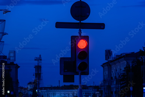 Red traffic light against the backdrop of an evening city.