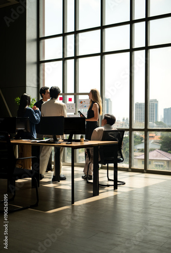 Wallpaper Mural Business team standing and talking during a meeting near a presentation board, discussing ideas, strategy Torontodigital.ca