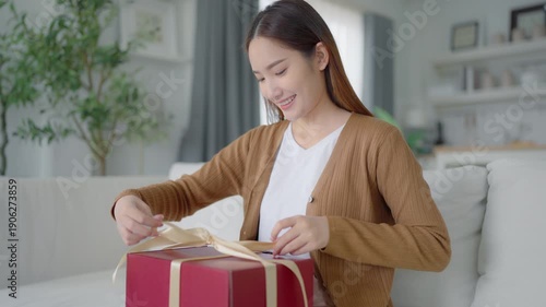 Asian young woman opening a gift box. Happy new year, Thanksgiving