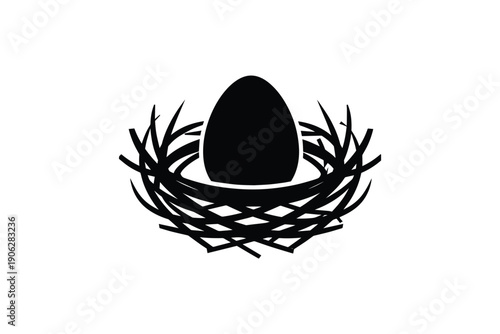 Single black egg in straw nest, symbol of life, new beginnings and fragile nature, white background