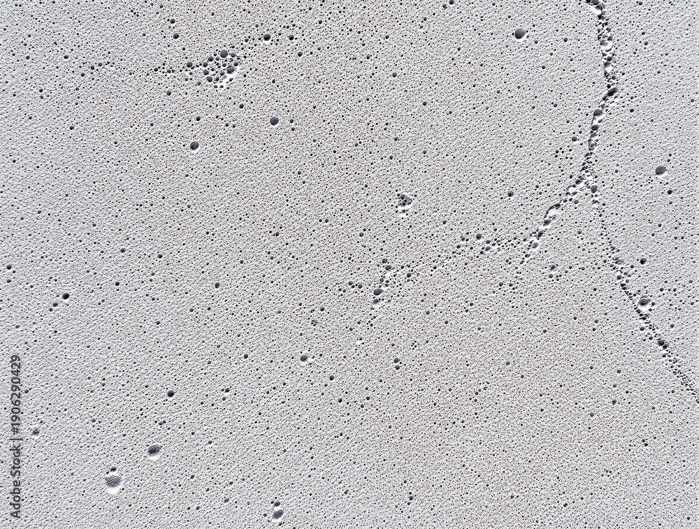 Fototapeta premium Abstract Grey Porous AAC Brick Surface Texture. High-detail top-view of a grey textured surface with tiny holes and pores, resembling concrete, stone, or solidified foam.