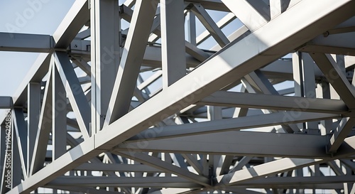 Industrial steel framework structure viewed from below with metal beams and girders against a clear sky