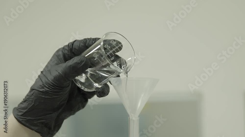 Beaker pouring liquid through funnel in laboratory 4k
