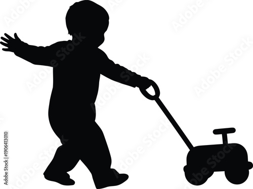 Silhouette of a toddler walking and pulling a toy tricycle