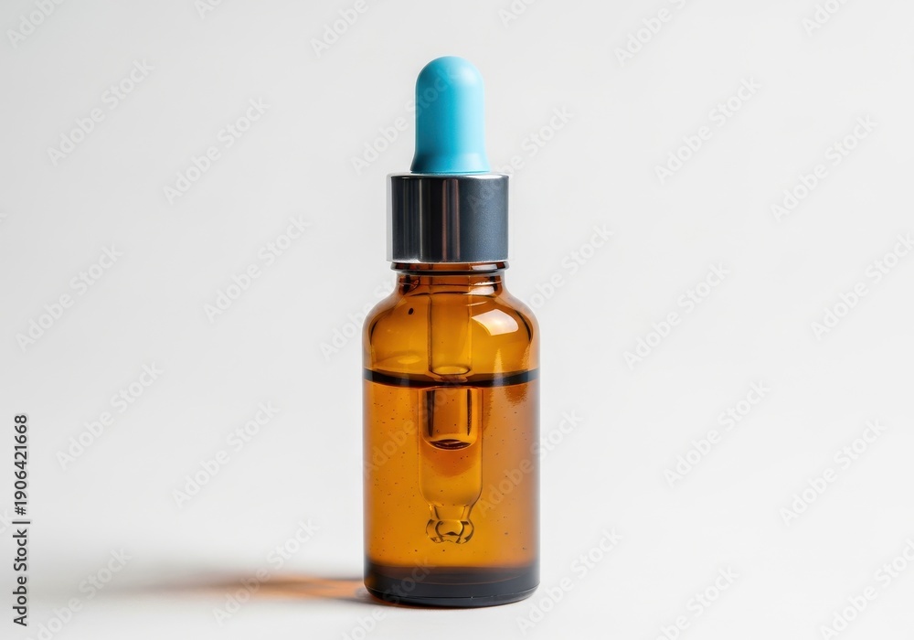 Fototapeta premium Amber glass dropper bottle with blue bulb stands against a light background