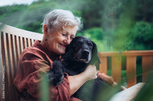 Photography Older woman with dog sitting on terrace.