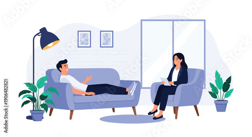 Therapy session with a man lying on a sofa talking to a female psychologist who is sitting in an armchair and taking notes in an office.