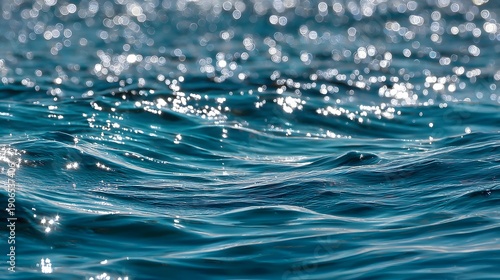 Close-up of sparkling blue water surface with gentle waves and sun reflections.