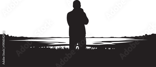 Silhouette of a man standing alone by the water