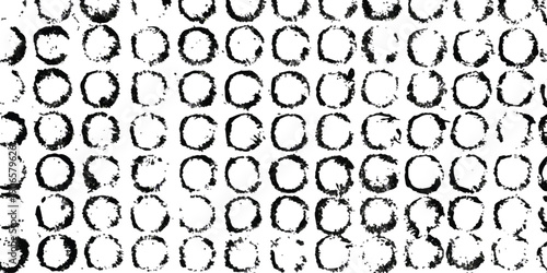Abstract black and white pattern featuring a repetitive grid of distressed, circular shapes