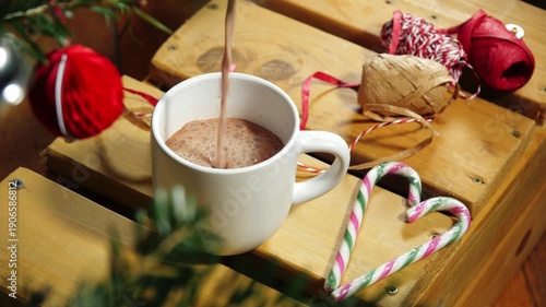 Pouring Hot chocolate surrounded by Christmas decorations