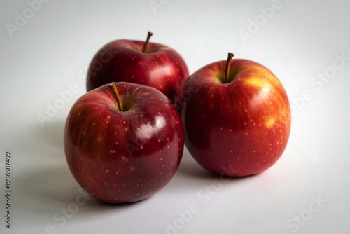 three vibrant red apples