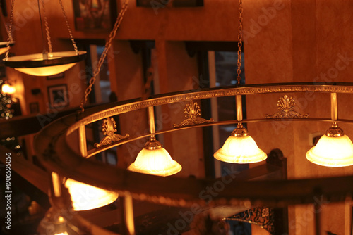 Warm hanging lamps over curved railing soft amber glow wood paneling blurred mezzanine atmospheric bokeh evening mood