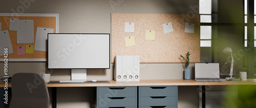Cuadro en lienzo Modern office workspace with blank desktop monitor, cork boards, laptop, and war