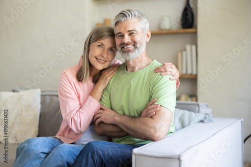 Older adults sitting close smiling in cozy living room
