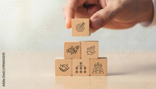 Business Strategy Planning. Hand placing target cube on pyramid structure with partnership innovation and growth icons, symbolizing balanced leadership strategic priorities and business achievement.
