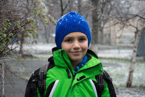 In winter, the street is a boy under falling snow.