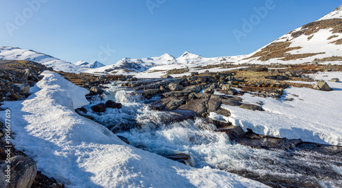 Fotografija Winter landscape showing snowy terrain and flowing water at Leirvassbu in Jotunh
