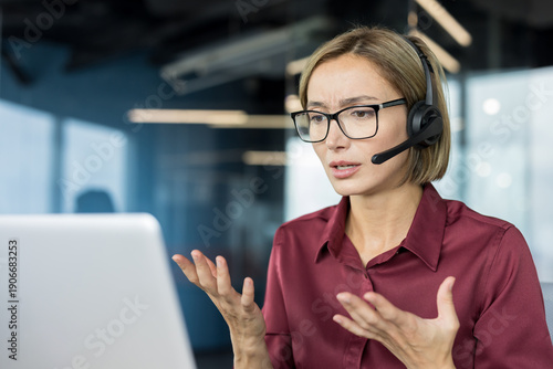 Foto Stressed customer service representative wearing a headset, communicating with c