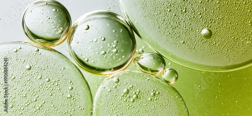 Green oil and bubbles creating a beauty product texture. Abstract wallpaper. Green oil droplets and bubbles suspended in water, forming a natural cosmetic texture