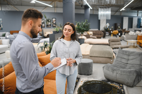 Obraz na płótnie Sales consultant assisting female buyer in furniture store
