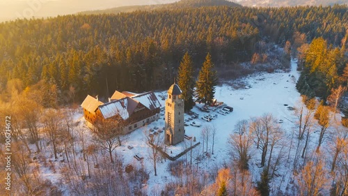 Explore the Bramberk lookout tower in the Jizera Mountains. Witness the snowy landscape and the surrounding forest. Enjoy the views from the tower and the quiet atmosphere of winter.