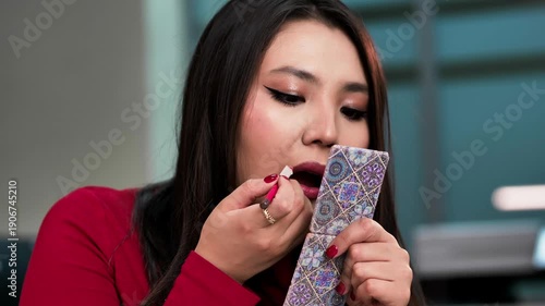 Young woman applying lip liner and lipstick in a close-up, finishing her makeup with a natural and radiant look.