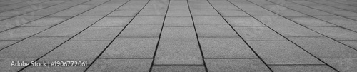 Abstract grey gray monochrome slabs stone floor pattern with geometric tile arrangement and perspective view creating a modern architectural surface in perspective view.