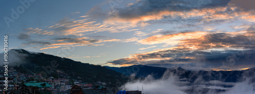 Sunset over misty valley mountain village with clouds, Kalimpong