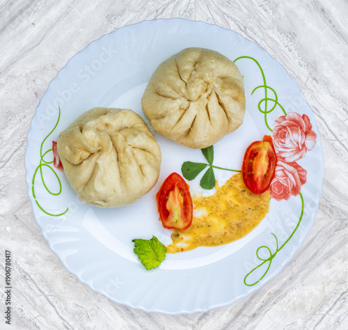 Steamed dumplings with tomato, sauce, and fresh mint