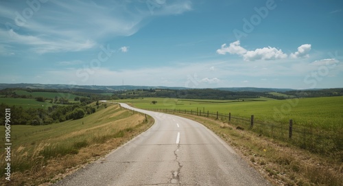 Wallpaper Mural Easygoing trip along a serpentine road through rolling green pastures and natural rural landscapes Torontodigital.ca