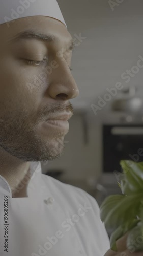 Wallpaper Mural Male chef with dark hair and beard inhales aroma of fresh basil leaves in a modern kitchen, showcasing culinary passion and attention to ingredient quality, hdr video with neutral color Torontodigital.ca