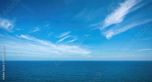 Bright blue sky gently meeting the ocean surface with thin clouds and a clear horizon