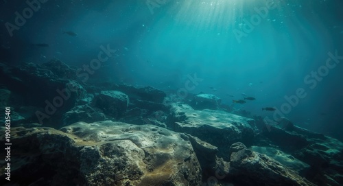 Filtered sunlight underwater highlights uneven rocks in a calm and quiet marine habitat