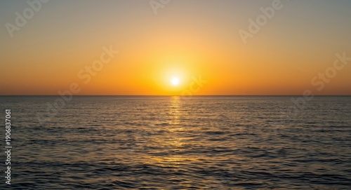 calm ocean waters under glowing sun at horizon