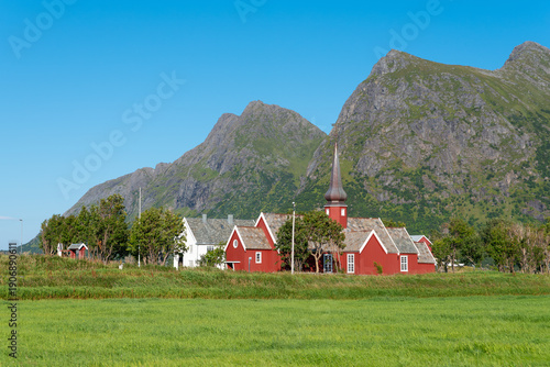 Landscape with a view of the Flakstad Church in Flakstad. In the background among other things the peaks of the mountains Blekktinden and Digertinden. Lofoten District in Norway