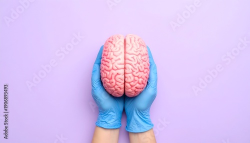 Brain held by blue gloved hands against a lavender background
