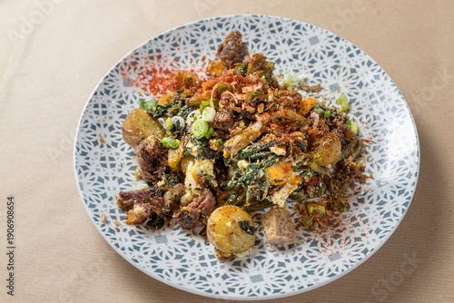 Greek dish of tender braised goat meat served with sautéed wild greens . Soft focus