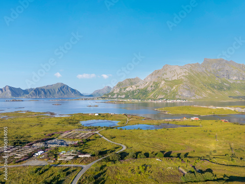 Aerial view near Fredvang overlooking salt marshes and coastal marshland with branching tidal creeks, with the peak of Hustinden in the background. Lofoten in Norway