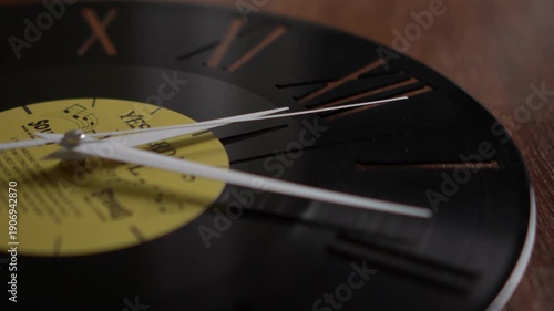 Close-up vinyl record wall clock with moving hands
