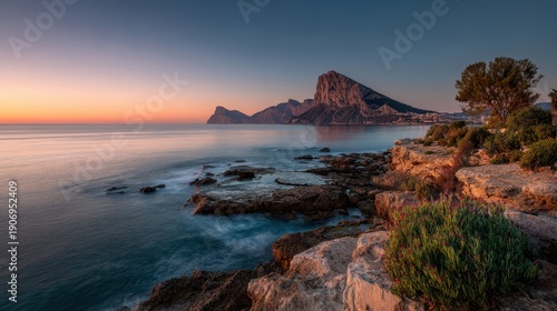 Panoramic view of the Rock of Gibraltar at sunrise over the Mediterranean Sea with rocky coastline