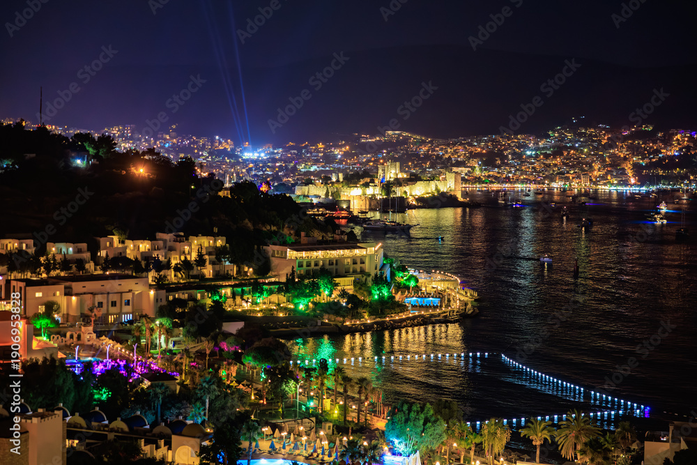 Obraz premium Vibrant nightscape of coastal city with illuminated waterfront and skyline