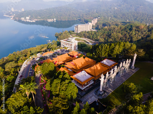 High-angle aerial close-up of Wen Wu Temple at Sun Moon Lake, Taiwan, highlighting ornate rooftops, colorful details, and layered traditional Chinese architecture against the lake and forest backdrop.