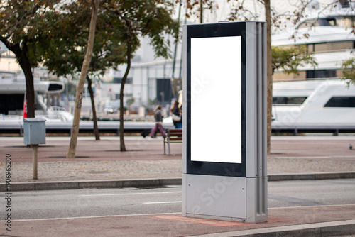 Blank vertical outdoor digital advertising screen mockup on a city street pavement, offering copy space for urban marketing campaigns and public information displays