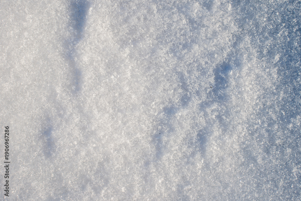 Obraz premium Natural snow texture with fine ice crystals creating a clean winter background. Minimal surface with copy space suitable for seasonal design, cold climate concepts and abstract winter visuals. 