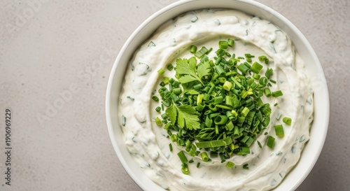 Close up of a savory creamy chive dip appetizer served in a white bowl, garnished with fresh green snipped herbs, spread, culinary, cuisine