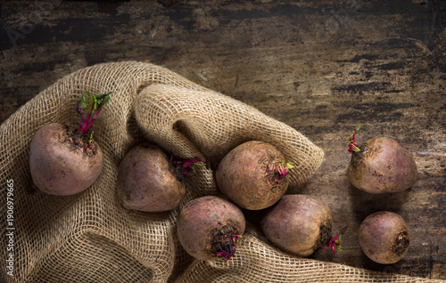 Fresh beetroots on burlap on rustic wooden table