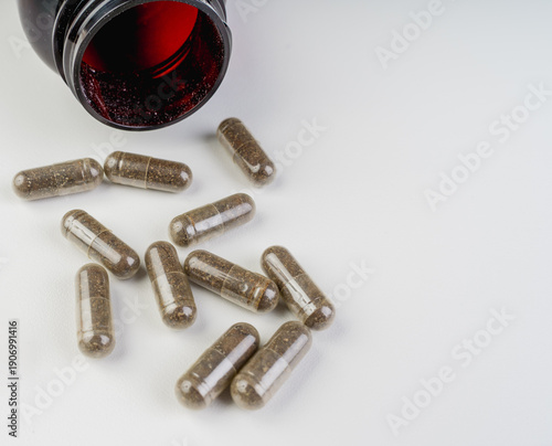 Wallpaper Mural Close-up of brown herbal capsules spilled from a glass bottle on a white background. Concept of natural supplements, wellness, alternative medicine and dietary support with clean copy space.
 Torontodigital.ca
